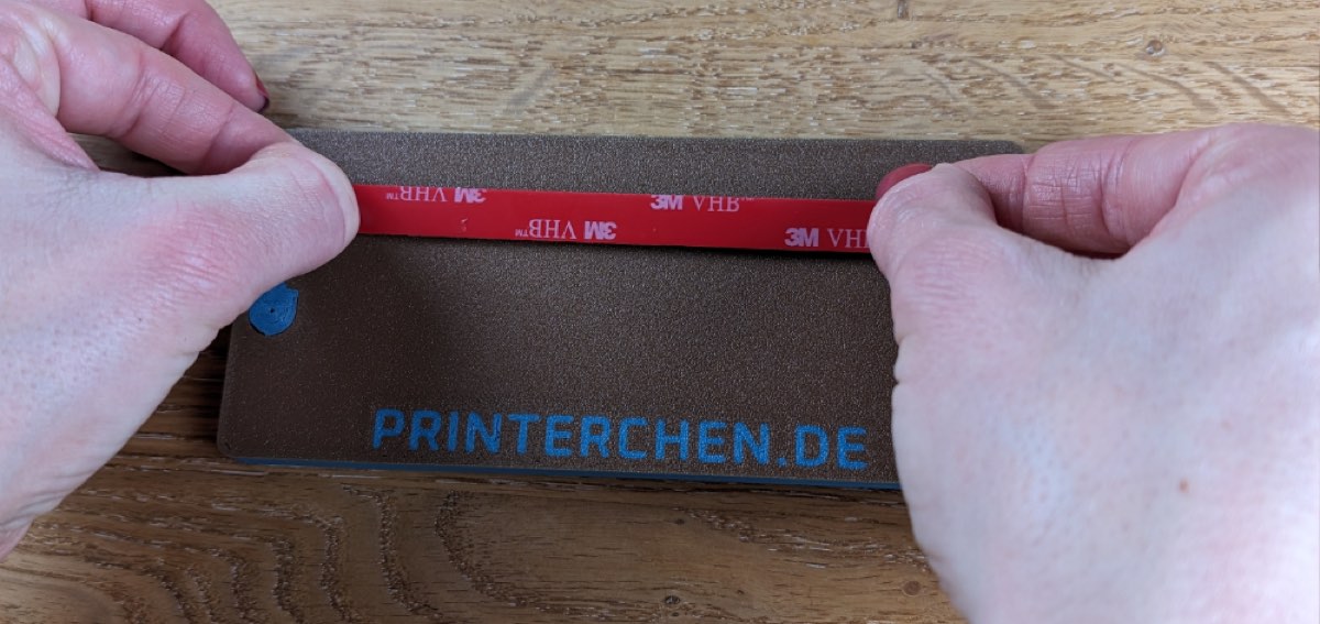 Doppelseitiges Klebeband auf der Rückseite anbringen